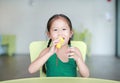 Adorable little Asian child girl sing a song by plastic microphone at the kid room Royalty Free Stock Photo