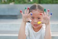 Adorable little Asian girl with colorful fingers painted