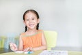 Adorable little Asian girl drawing and painting with water color on paper in children room with looking at camera Royalty Free Stock Photo