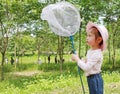 Adorable little asian girl in a field with insect net in summer season Royalty Free Stock Photo