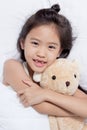 Adorable little Asian girl sleep on her bed with bear doll Royalty Free Stock Photo