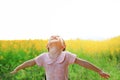 Adorable little Asian kid girl feeling free with relax arms wide open in Sunhemp field with mountains and sunlight. Yellow flowers Royalty Free Stock Photo