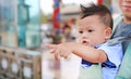 Adorable little baby boy pointing something with father carry by hipseat outdoor. Close up Royalty Free Stock Photo