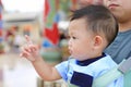 Adorable little baby boy pointing something with father carry by hipseat outdoor. Close up Royalty Free Stock Photo