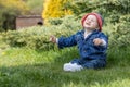 Adorable little baby boy is relaxing sitting on the grass outdoors Royalty Free Stock Photo