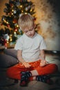adorable little baby boy sitting in front of a christmas tree. Christmas Child Open Present Gift, Happy Baby Boy looking Royalty Free Stock Photo