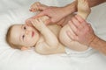 Adorable little baby child lying on bed. Cute smiling little infant girl on white soft blanket Royalty Free Stock Photo