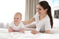 Adorable little baby crawling near mother on bed Royalty Free Stock Photo