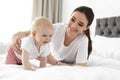 Adorable little baby crawling near mother on bed Royalty Free Stock Photo