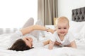 Adorable little baby crawling near mother on bed Royalty Free Stock Photo