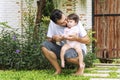 Little baby daughter sitting on her father scoop while rest in the garden at home. Handsome single dad holding and Royalty Free Stock Photo