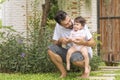 Little baby daughter sitting on her father scoop while rest in the garden at home. Handsome single dad holding and Royalty Free Stock Photo