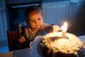 Adorable little baby girl celebrating first birthday. Child blowing one candle on homemade baked cake, indoor. Royalty Free Stock Photo