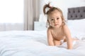 Adorable little baby girl crawling on bed in room Royalty Free Stock Photo