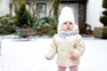 Adorable little baby girl making first steps outdoors in winter. Cute toddler learning walking. Child having fun on cold Royalty Free Stock Photo