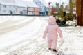 Adorable little baby girl making first steps outdoors in winter. Cute toddler learning walking. Child having fun on cold Royalty Free Stock Photo