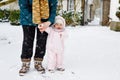 Adorable little baby girl making first steps outdoors in winter through snow. Cute toddler learning walking. Mother Royalty Free Stock Photo