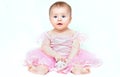 Adorable little baby girl in pink dress playing with her pink shoe Royalty Free Stock Photo