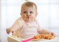 Adorable little baby one year eating pasta indoor. Funny toddler child with spaghetti. Cute kid and healthy food. Royalty Free Stock Photo