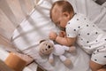 Adorable little baby with pacifier and toy sleeping in crib indoors, above view Royalty Free Stock Photo