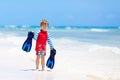 Adorable little blond kid boy having fun on tropical beach of Maldives. Excited child playing and surfing in sun Royalty Free Stock Photo