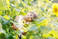 Adorable little blond kid boy on summer sunflower field outdoors Royalty Free Stock Photo