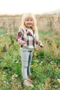 Adorable little blonde girl laughing in a meadow. Happy child on a summer walk. Stylish girl having fun in a summer time. Happy Royalty Free Stock Photo