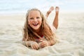 Adorable little blonde girl relax on sandy beach enjoy sea Royalty Free Stock Photo