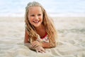 Adorable little blonde girl relax on sandy beach enjoy sea Royalty Free Stock Photo