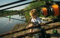 Adorable little boy fishing from wooden dock on lake Royalty Free Stock Photo