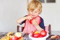 Adorable little boy helping and baking apple pie in home''s kitc Royalty Free Stock Photo