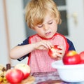 Adorable little boy helping and baking apple pie in home''s kitc Royalty Free Stock Photo