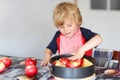 Adorable little boy helping and baking apple pie in home's kitchen Royalty Free Stock Photo