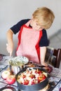 Adorable little boy helping and baking apple pie in home's kitchen Royalty Free Stock Photo