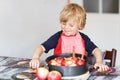 Adorable little boy helping and baking apple pie in home''s kitc Royalty Free Stock Photo