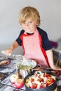 Adorable little boy helping and baking apple pie in home's kitchen Royalty Free Stock Photo