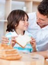 Adorable little boy and his father eating bread