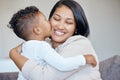 Adorable little boy kissing his mother on the cheek. Happy mixed race mother receiving love and affection from her son Royalty Free Stock Photo