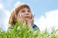 Cute little boy laying on green grass over blue sky spring natur