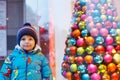 Adorable little boy looking through the window at Christmas decoration in the shop Royalty Free Stock Photo