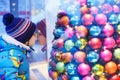 Adorable little boy looking through the window at Christmas decoration in the shop Royalty Free Stock Photo