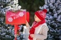 Adorable little boy with red hat and green glasses sending her letter to Santa, Christmas time Royalty Free Stock Photo