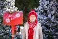 Adorable little boy with red hat and green glasses sending her letter to Santa, Christmas time Royalty Free Stock Photo
