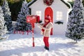 Adorable little boy with red hat and green glasses sending her letter to Santa, Christmas time Royalty Free Stock Photo