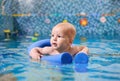 Adorable little boy swimming in pool with pool-noodle. Royalty Free Stock Photo