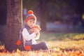 Adorable little boy with teddy bear in park on autumn day Royalty Free Stock Photo