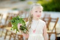 Adorable little bridesmaid holding beautiful flower bouquets after wedding cemerony outdoors Royalty Free Stock Photo