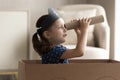 Adorable little Caucasian girl in pirate hat looking in spyglass