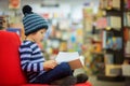 Adorable little child, boy, sitting in a book store Royalty Free Stock Photo