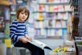 Adorable little child, boy, sitting in a book store Royalty Free Stock Photo